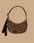 A leopard print curved crescent shaped handbag with a black strap that can adjust from a shoulder bag length to a crossbody.