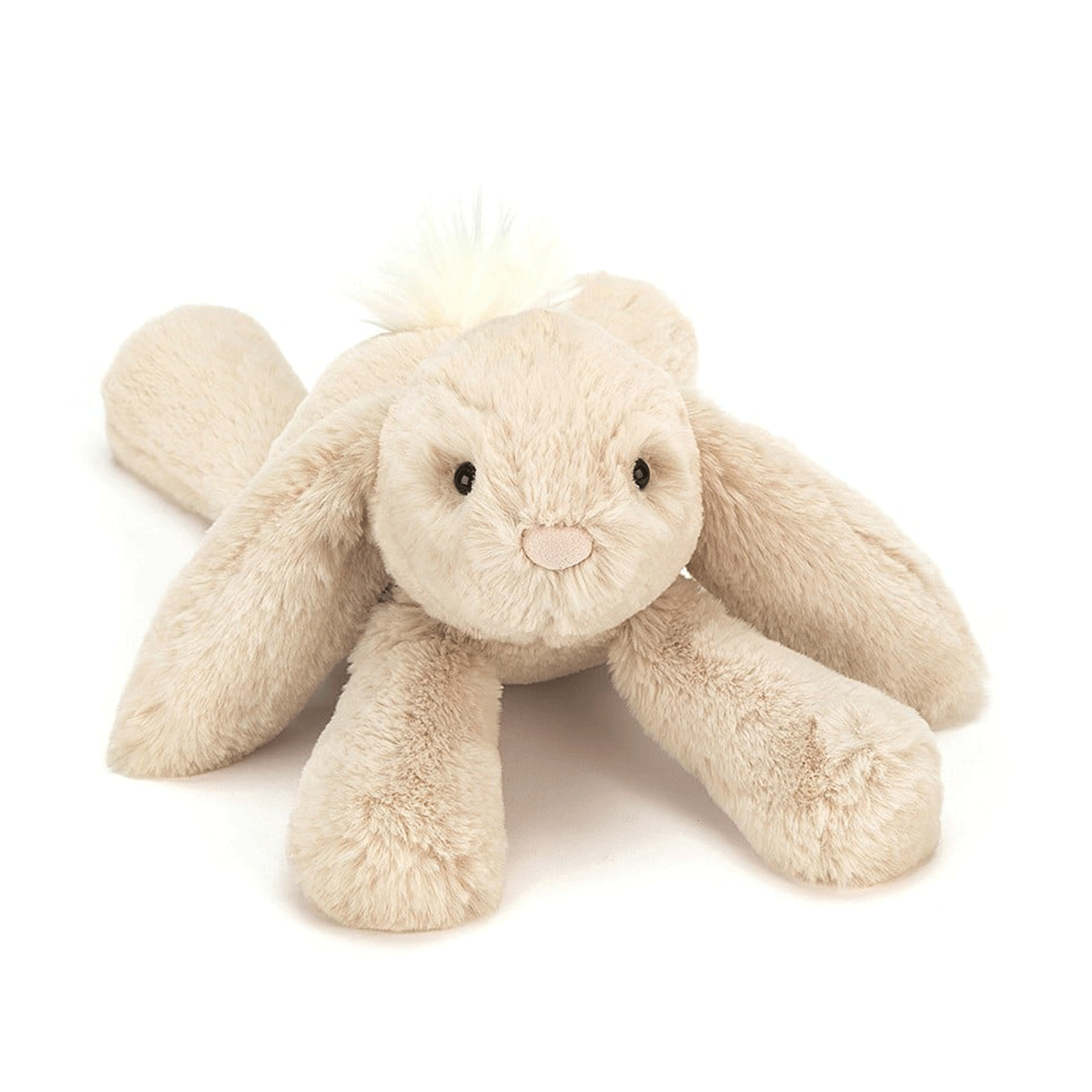 On a white background is a tan / ivory bunny stuffed animal with floppy ears and a fluffy tail.