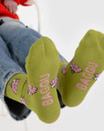 A pair of chartreuse green and pink crew socks with a Snoopy puffer jacket print.
