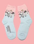 A pair of blue and pink crew socks with a graphic of snoopy and a snowman.