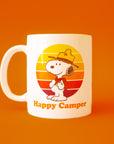 A white mug with a yellow orange and red graphic of Snoopy as a Beagle Scout and text underneath that reads, 'Happy Camper'