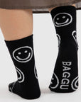 A pair of black socks with white smiley faces on them.
