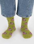 A pair of chartreuse green and pink crew socks with a Snoopy puffer jacket print.