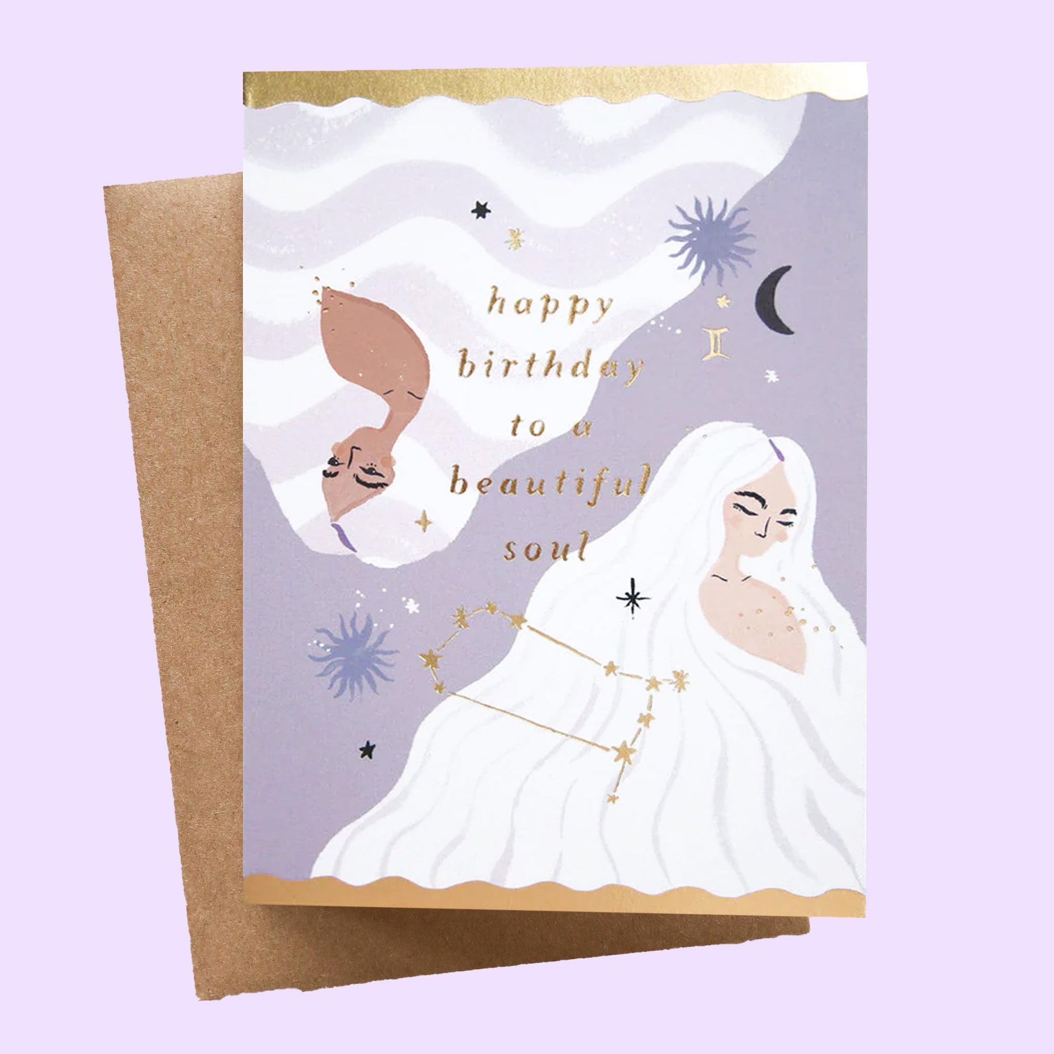 On a neutral background is a card with a woman on the front and gold text that reads, &quot;happy birthday to a beautiful soul&quot; along with star and moon illustrations.
