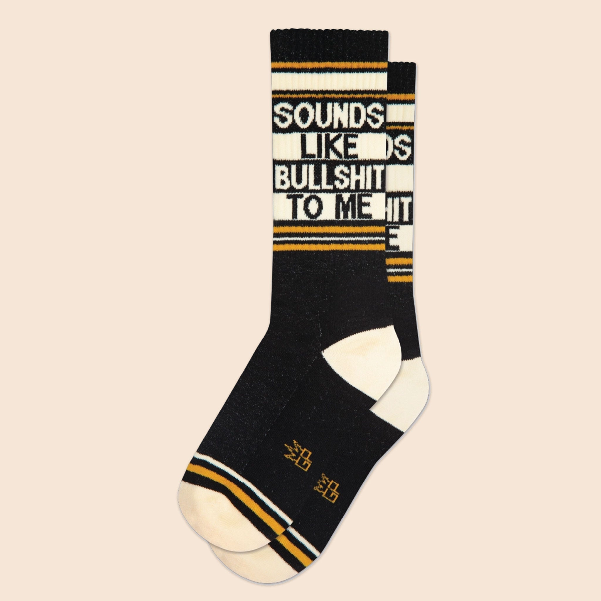 On a neutral background is a pair of black socks with yellow and white details along with text that reads, &quot;Sounds Like Bullshit To Me&quot;.