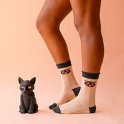 A pair of pink and cream striped socks with black details and a spooky cat graphic.