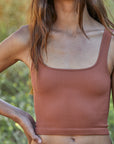 A gingerbread brown colored square neck cropped tank top.