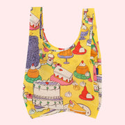A yellow nylon tote bag with a colorful pattern of various desserts.