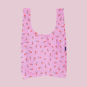 A pink nylon tote bag with a red and green flower print.
