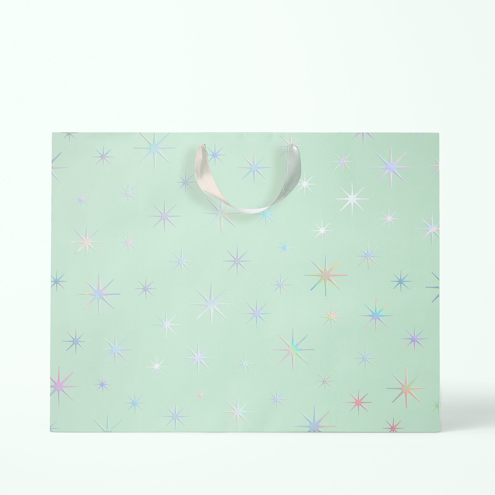 A mint colored gift bags with silver holographic star patterns and silver ribbon handles.
