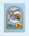 A blue notebook with a graphic of someone getting bit by a shark and text underneath that reads, 'Stay Positive'.
