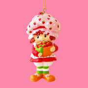 An ornament in the shape of the iconic character Strawberry Shortcake holding a basket of berries.