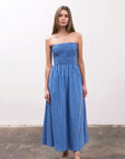 Model is wearing a strapless A-line midi dress, in a stripe blue pattern.