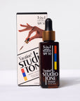 A dropper style bottle of bronzing drops with text that reads, '3-in-1 SPF 50 Vacation Studio Tone'.