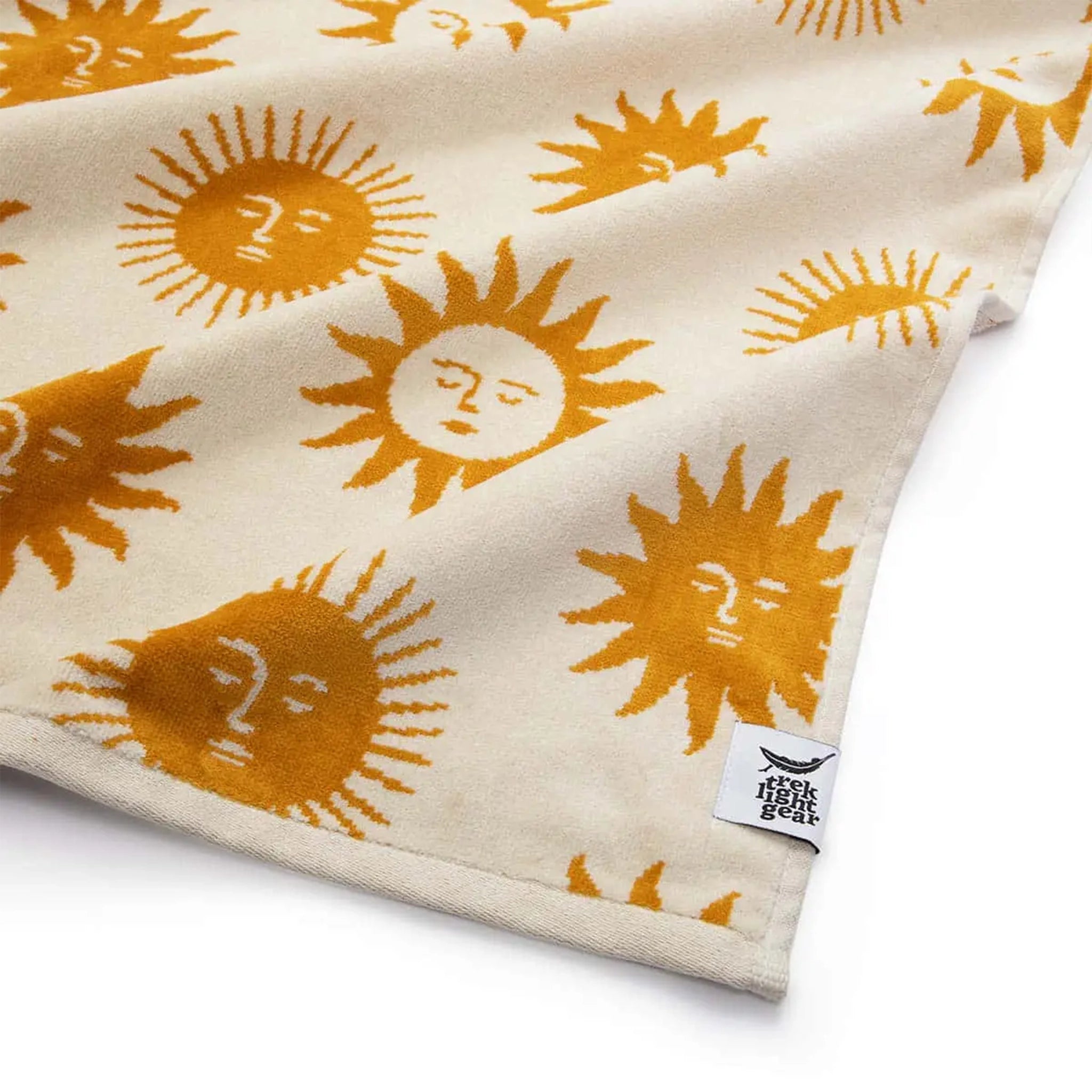 A cream and mustard yellow beach / bath towel with a sun design on the front and back.