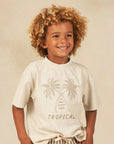 A neutral t-shirt with a palm tree graphic on the front and text in between that reads, "Only Sunny Days Tropical".