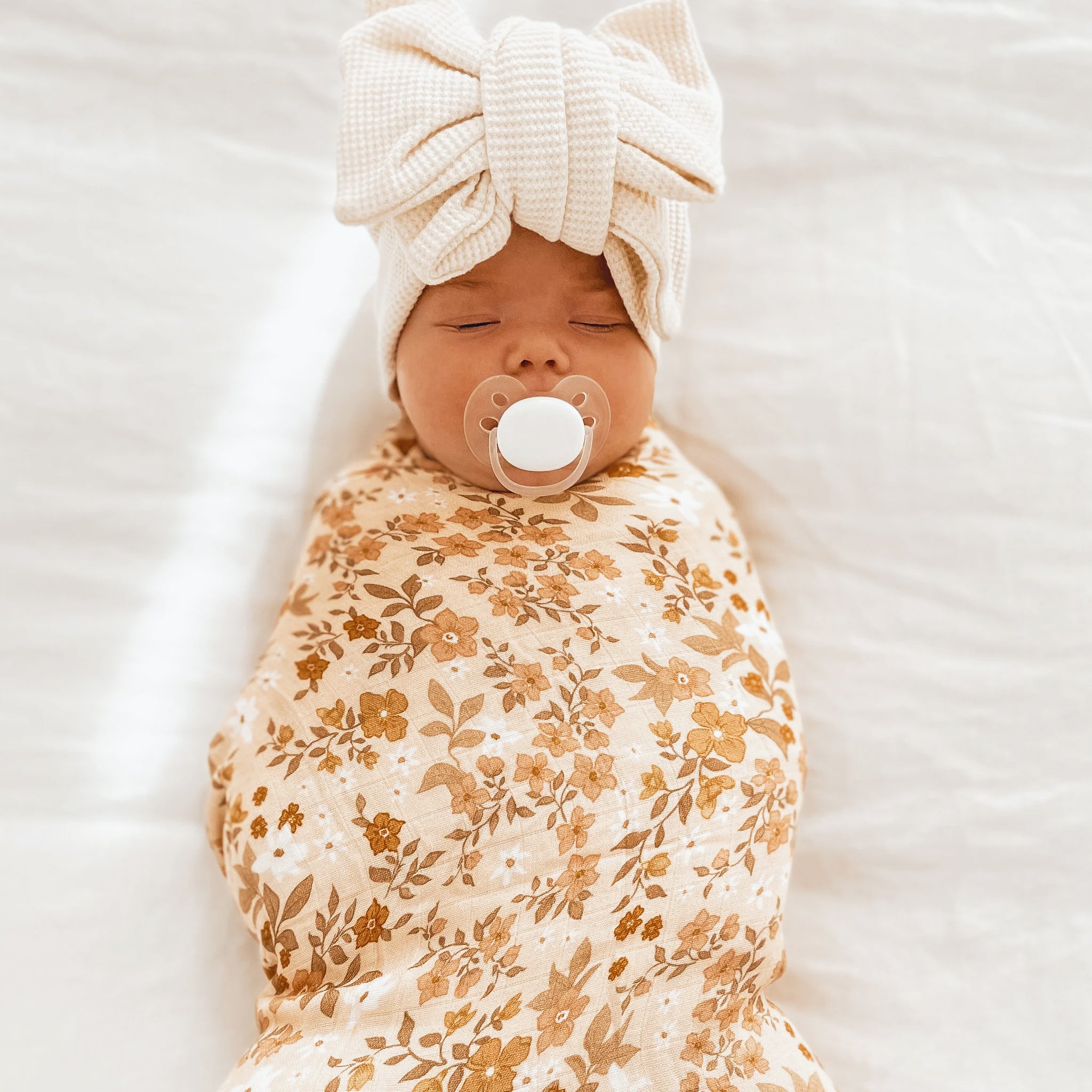 A floral and neutral organic muslin swaddle. 