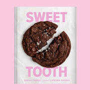 A white book cover with a chocolate cookie on the cover and pink text above and below that reads, 'Sweet Tooth'.