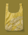 A green reusable nylon tote bag with a swiss cheese leaf pattern.