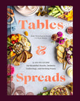 A bookcover with a photo of a tablescape filled with colorful foods and dishes and text in the center that reads, 'Tables & Spreads'.