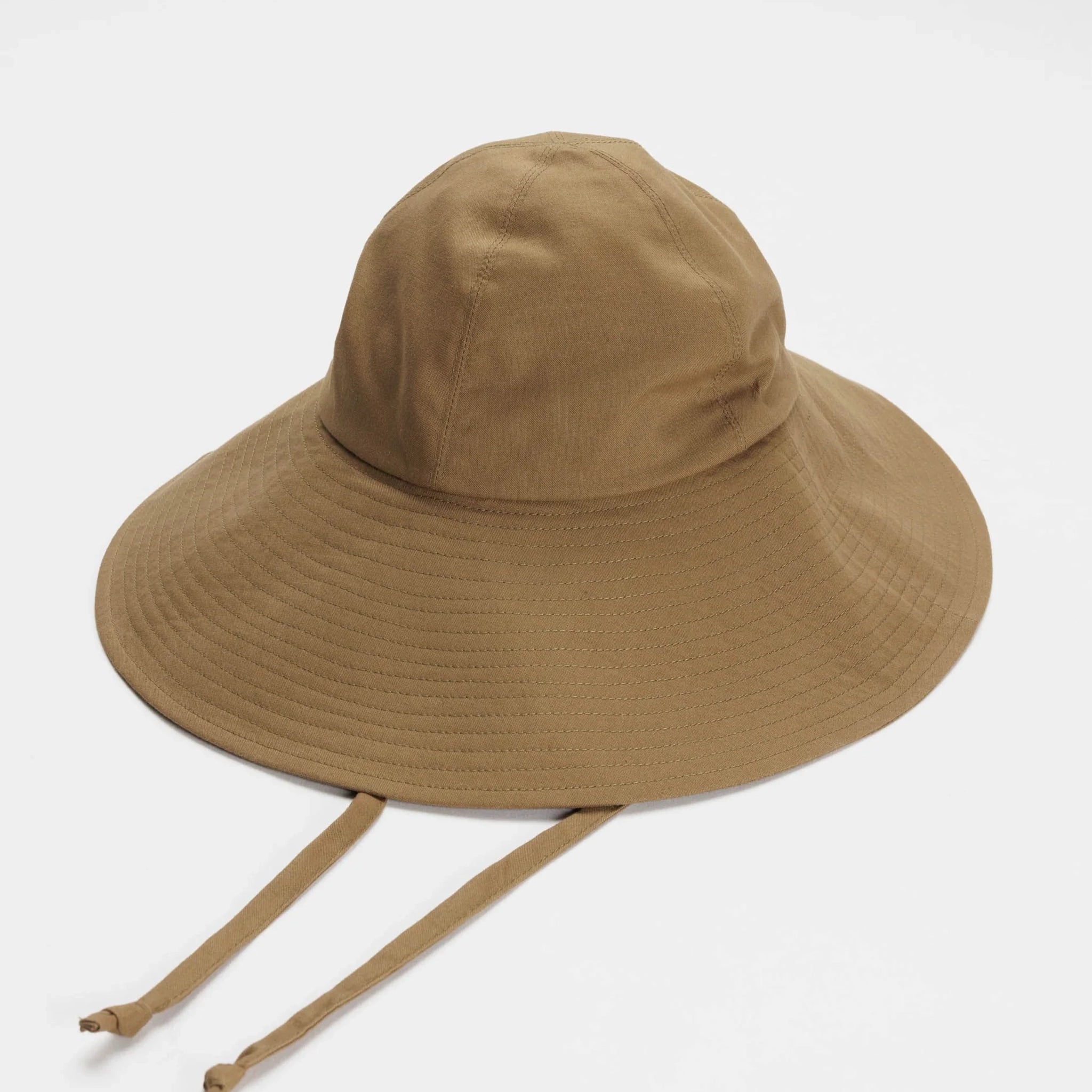 On a white background is a flexible sun hat in a brown shad with a wide brim and two straps for securing around the neck.