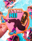 An air freshener with a graphic that looks like Taylor Swift with text that reads, "It's Me, Hi!".