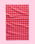 A red and pink gingham print tea towel with a waffle weave.