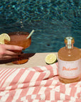 A photo of a poolside image with a cocktail mix and a margarita glass.