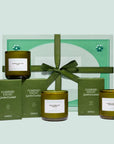 A set of three green glass jarred candles in boxes and in a mint green gift box.