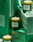 A set of three green glass jarred candles in boxes and in a mint green gift box.