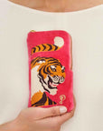 A hot pink velvet pouch with a tiger design and a zipper closure.