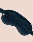 A dark blue sleeping eye mask with a tiger embroidery on the front.