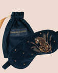 A dark blue sleeping eye mask with a tiger embroidery on the front.