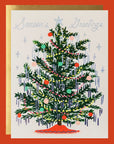Cream colored greeting card with a green Christmas tree on it. The tree is decorated with multi colored ornaments and holographic tinsel. The card reads, "Season's Greetings" and has a holographic silver star at the top of the tree.