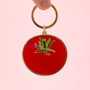 A tomato shaped enamel keychain.