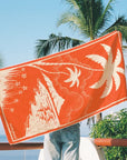 A beach towel with a palm tree design.