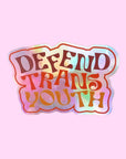 A holographic sticker with text that reads, "Defend Trans Youth".