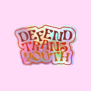 A holographic sticker with text that reads, "Defend Trans Youth".