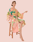 A green and apricot colored kimono robe with a tropical floral and foliage print.