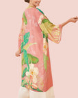 A green and apricot colored kimono robe with a tropical floral and foliage print.