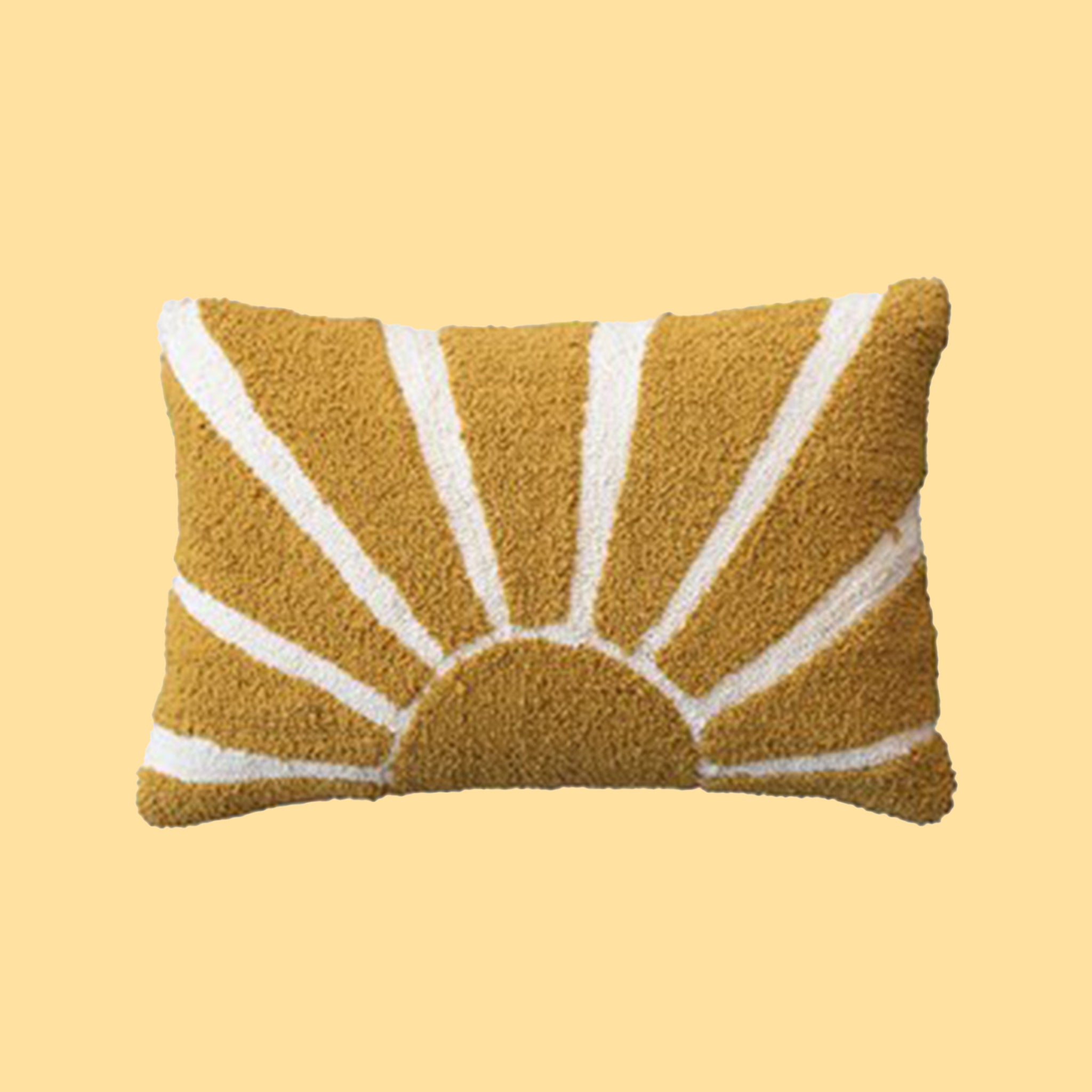 On a yellow background is a yellow and cream lumbar pillow with a sunshine design.