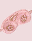 A pink sleeping mask with turtle embroidering.
