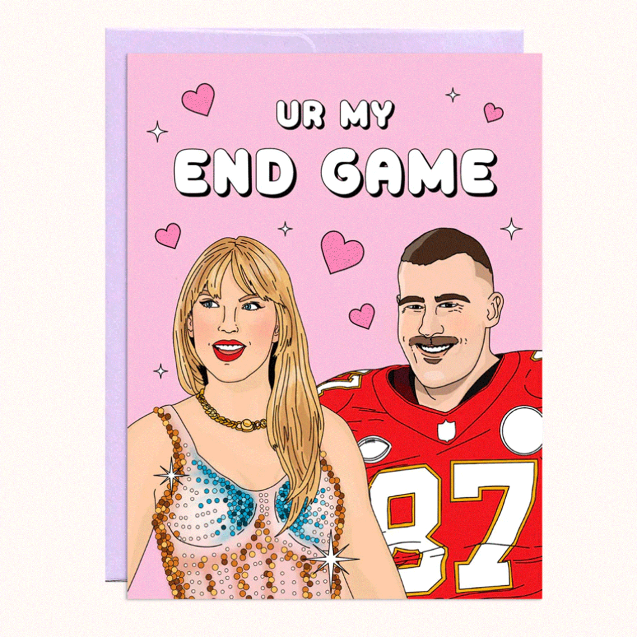 On a white background is a pink card with an illustration that looks like Taylor Swift and Travis Kelce along with text above them that reads, &quot;Ur My End Game&quot;. The card comes with a light purple envelope. 