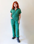 A green short sleeve jumpsuit with a zipper up the front.