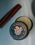 A round tin of solid hair pomade with an illustration of an octopus on the lid and text that reads, 'Pilgram's Pomade Light - Medium Hold'.