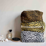 A olive greenish/brown canvas cosmetics case with a black zebra stripe pattern.