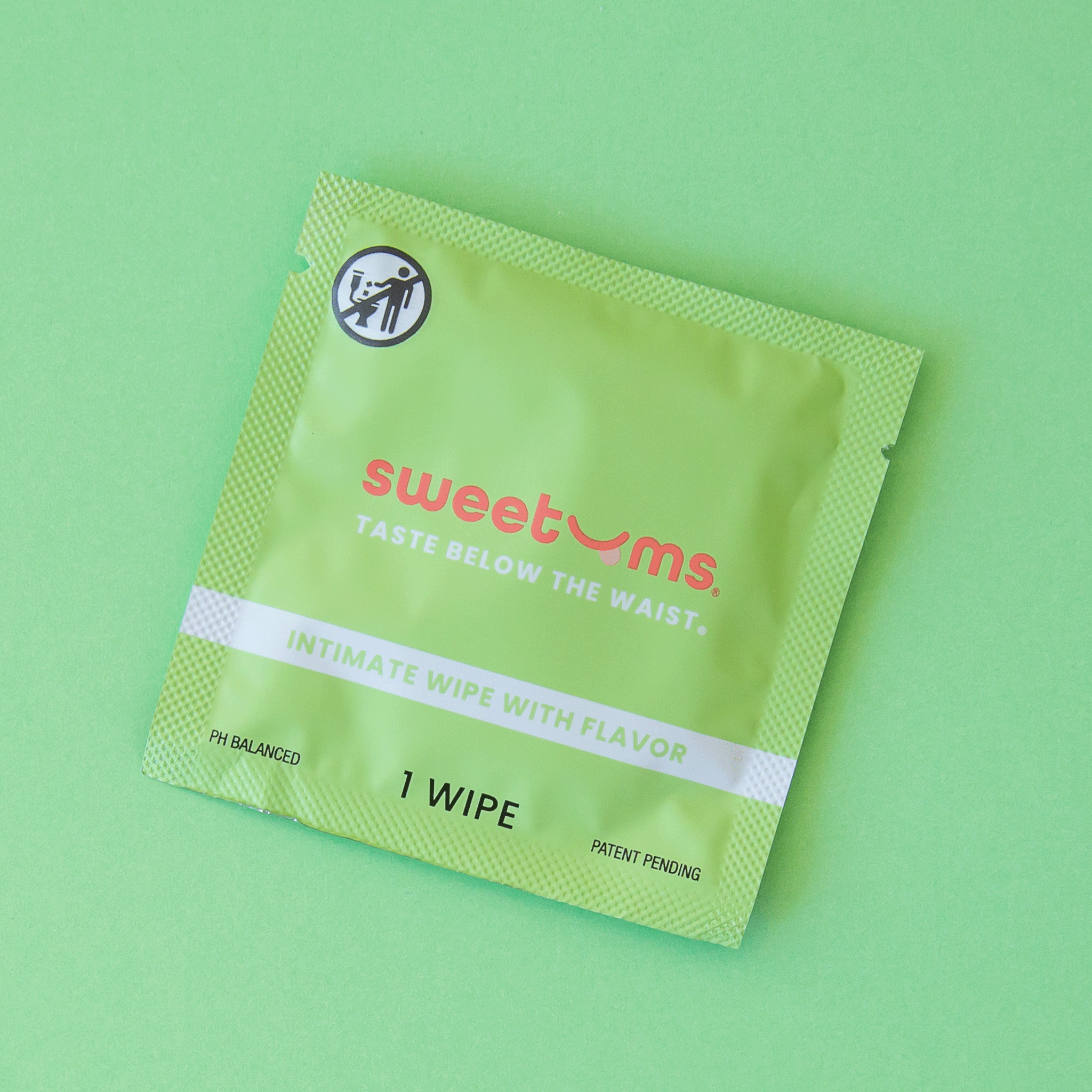 On a green background is a green packet with a single feminine wipe inside. The packaging reads, &quot;sweetums taste below the waist&quot;. 