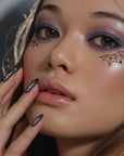 A model wearing the spider web eye patch speckles.