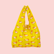 A yellow nylon tote bag with a wiener dog hot dog print.