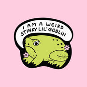 A green frog shaped sticker with a speech bubble above that reads, 'I am a weird stinky lil' goblin'.
